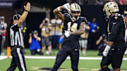 Sep 14, 2025; New Orleans, Louisiana, USA;  New Orleans Saints wide receiver Devaughn Vele (14) reacts to scoring a touchdown against San Francisco 49ers safety Jason Pinnock (25) during the second half at Caesars Superdome. Mandatory Credit: Stephen Lew-Imagn Images