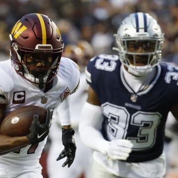 Jan 8, 2023; Landover, Maryland, USA; Washington Commanders wide receiver Terry McLaurin (17) runs with the ball for a touchdown as Dallas Cowboys linebacker Damone Clark (33) chases during the first quarter at FedExField. Mandatory Credit: Geoff Burke-USA TODAY Sports
