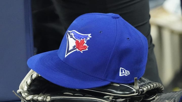 Apr 27, 2024; Toronto, Ontario, CAN; A Toronto Blue Jays hat and glove in the dugout during the third inning against the Los Angeles Dodgers at Rogers Centre. Mandatory Credit: John E. Sokolowski-Imagn Images