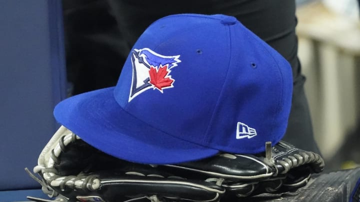 Apr 27, 2024; Toronto, Ontario, CAN; A Toronto Blue Jays hat and glove in the dugout during the third inning against the Los Angeles Dodgers at Rogers Centre. Mandatory Credit: John E. Sokolowski-USA TODAY Sports