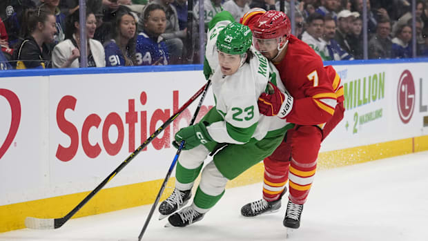 Hockey player defends against puck carrie