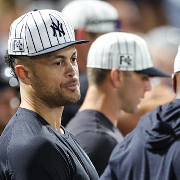 Mar 14, 2025; Tampa, Florida, USA; New York Yankees designated hitter Giancarlo Stanton (27) looks on from the dugout against the Philadelphia Phillies.