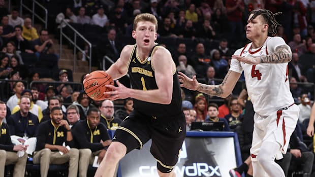 Michigan Wolverines center Danny Wolf (1) drives past Arkansas Razorbacks forward Trevon Brazile (4) during a game.