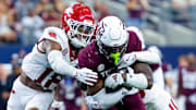 Texas A&M Aggies running back Le'Veon Moss (8) is drug down by Arkansas Razorbacks defensive back TJ Metcalf (18) defends during the second half at AT&T Stadium. 