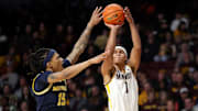 Jan 16, 2025; Minneapolis, Minnesota, USA; Minnesota Golden Gophers guard Isaac Asuma (1) shoots as Michigan Wolverines guard Rubin Jones (15) defends during the first half at Williams Arena. Mandatory Credit: Matt Krohn-Imagn Images