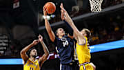 Penn State Nittany Lions forward Yanic Konan Niederhauser shoots as Minnesota Golden Gophers forward Parker Fox (23) defends during the second half of a Big Ten basketball game. 
