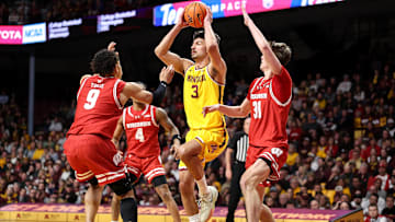 Mar 5, 2025; Minneapolis, Minnesota, USA; Minnesota Golden Gophers forward Dawson Garcia (3) passes as Wisconsin Badgers guard John Tonje (9) and forward Nolan Winter (31) defend during the first half at Williams Arena. Mandatory Credit: Matt Krohn-Imagn Images
