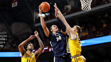 Penn State Nittany Lions forward Yanic Konan Niederhauser shoots as Minnesota Golden Gophers forward Parker Fox (23) defends during the second half of a Big Ten basketball game. 