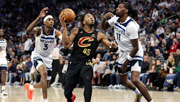 Jan 18, 2025; Minneapolis, Minnesota, USA; Cleveland Cavaliers guard Donovan Mitchell (45) shoots as Minnesota Timberwolves center Naz Reid (11) and forward Jaden McDaniels (3) defend during the fourth quarter at Target Center. Mandatory Credit: Matt Krohn-Imagn Images