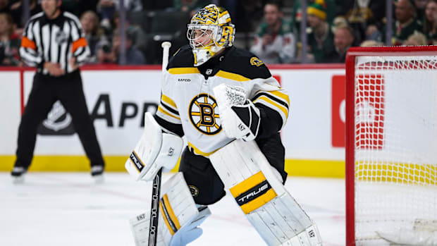 Hockey goalie in white uniform defends the net