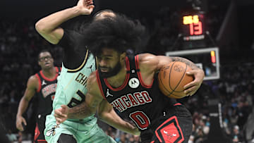 Dec 30, 2024; Charlotte, North Carolina, USA;  Chicago Bulls guard Coby White (0) drives past Charlotte Hornets guard Isaiah Wong (21) during the second half at the Spectrum Center. Mandatory Credit: Sam Sharpe-Imagn Images