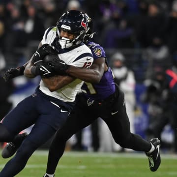 Jan 20, 2024; Baltimore, MD, USA; Houston Texans wide receiver Nico Collins (12) runs the ball against Baltimore Ravens cornerback Brandon Stephens (21) during the second quarter of a 2024 AFC divisional round game at M&T Bank Stadium. Mandatory Credit: Tommy Gilligan-USA TODAY Sports