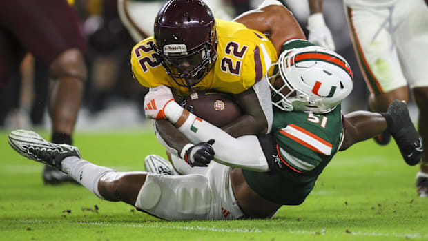 Miami Hurricanes linebacker Francisco Mauigoa (51) tackles Bethune Cookman Wildcats running back Jouvensly Bazil (22)