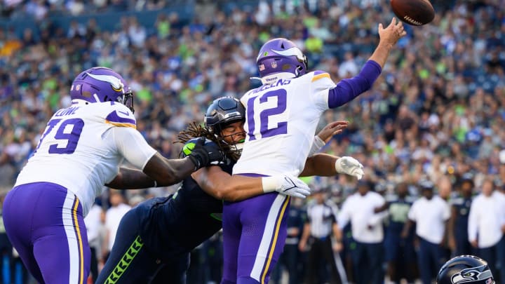 Aug 10, 2023; Seattle, Washington, USA; Seattle Seahawks defensive end Mike Morris (94) hits Minnesota Vikings quarterback Nick Mullens (12) while passing the ball during the first half at Lumen Field.