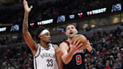 Mar 13, 2025; Chicago, Illinois, USA; Brooklyn Nets center Nic Claxton (33) defends Chicago Bulls center Nikola Vucevic (9) during the first quarter at United Center. Mandatory Credit: David Banks-Imagn Images