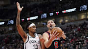 Mar 13, 2025; Chicago, Illinois, USA; Brooklyn Nets center Nic Claxton (33) defends Chicago Bulls center Nikola Vucevic (9) during the first quarter at United Center. Mandatory Credit: David Banks-Imagn Images