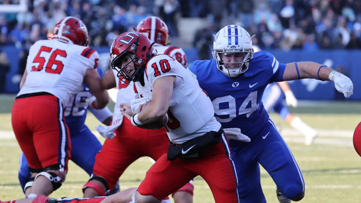 Nov 19, 2022; Provo, Utah, USA; Utah Tech Trailblazers quarterback Victor Gabalis (10) is pushed out of the pocket by Brigham Young Cougars defensive lineman John Nelson (94) in the third quarter at LaVell Edwards Stadium.