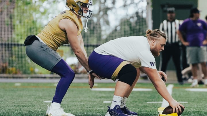 Will Rogers works with center Landen Hatchett during spring ball. 