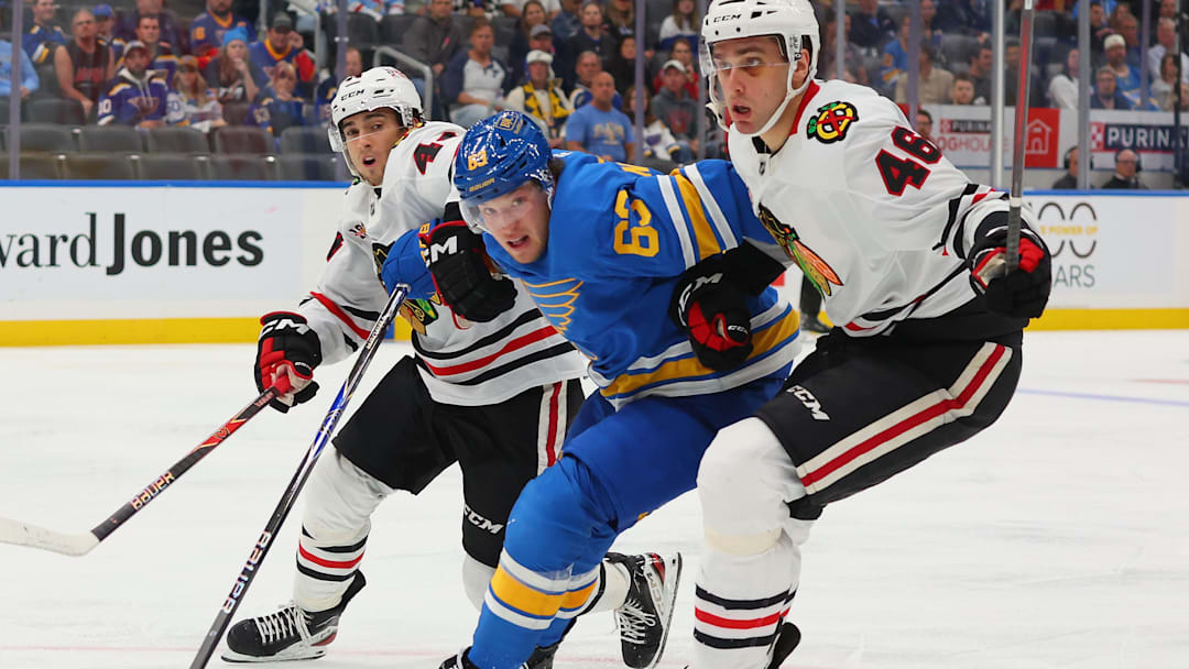 St. Louis Blues F Jake Neighbours engaged in a battle with two opposing skaters St. Louis Blues F Jake Neighbours engaged in a battle with two opposing skaters