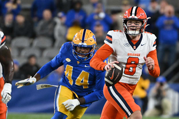 Syracuse Orange quarterback Kyle McCord scrambles away from Pittsburgh Panthers defensive lineman Chief Borders.