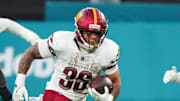 Washington Commanders running back Chris Rodriguez Jr. (36) carries the ball against the Miami Dolphins in the second quarter during the 2025 NFL Madrid Game at Santiago Bernabeu Stadium. Mandatory Credit: Kirby Lee-Imagn Images