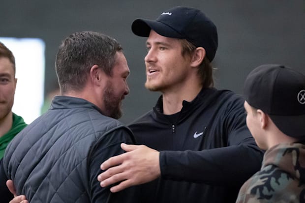 Oregon head coach Dan Lanning, left, hugs Los Angeles Chargers quarterback and former Oregon quarterback Justin Herbert durin