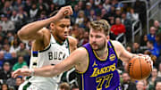 Mar 13, 2025; Milwaukee, Wisconsin, USA;  Los Angeles Lakers guard Luka Doncic (77) drives to the basket against Milwaukee Bucks forward Giannis Antetokounmpo (34) in the third quarter at Fiserv Forum. Mandatory Credit: Benny Sieu-Imagn Images