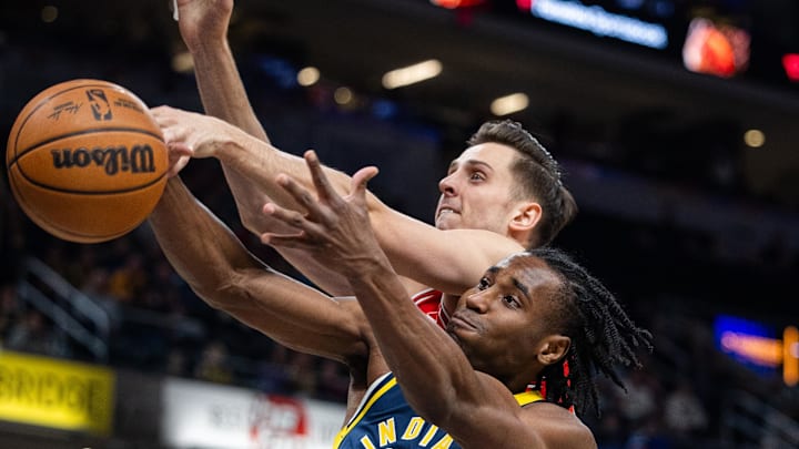 Mar 2, 2025; Indianapolis, Indiana, USA; Chicago Bulls forward Zach Collins (12) and Indiana Pacers forward Aaron Nesmith (23) fight for a rebound in the first half  at Gainbridge Fieldhouse. Mandatory Credit: Trevor Ruszkowski-Imagn Images
