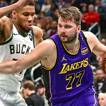 Mar 13, 2025; Milwaukee, Wisconsin, USA;  Los Angeles Lakers guard Luka Doncic (77) drives to the basket against Milwaukee Bucks forward Giannis Antetokounmpo (34) in the third quarter at Fiserv Forum. Mandatory Credit: Benny Sieu-Imagn Images