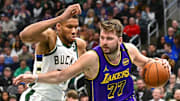 Mar 13, 2025; Milwaukee, Wisconsin, USA;  Los Angeles Lakers guard Luka Doncic (77) drives to the basket against Milwaukee Bucks forward Giannis Antetokounmpo (34) in the third quarter at Fiserv Forum. Mandatory Credit: Benny Sieu-Imagn Images
