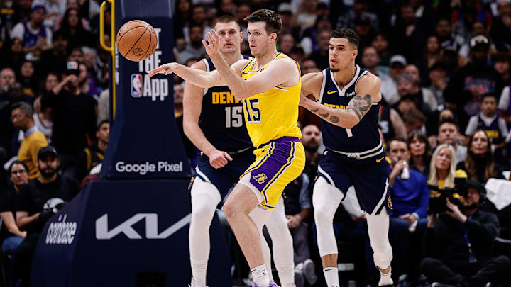 Apr 29, 2024; Denver, Colorado, USA; Los Angeles Lakers guard Austin Reaves (15) passes the ball as Denver Nuggets center Nikola Jokic (15) and forward Michael Porter Jr. (1) defend in the third quarter during game five of the first round for the 2024 NBA playoffs at Ball Arena. Mandatory Credit: Isaiah J. Downing-Imagn Images