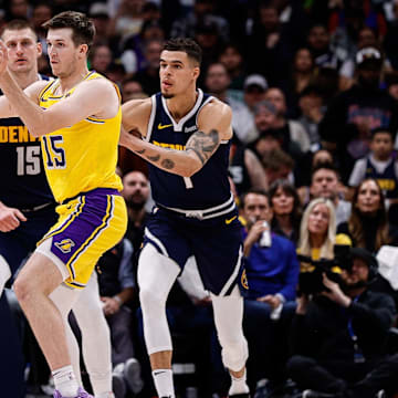 Apr 29, 2024; Denver, Colorado, USA; Los Angeles Lakers guard Austin Reaves (15) passes the ball as Denver Nuggets center Nikola Jokic (15) and forward Michael Porter Jr. (1) defend in the third quarter during game five of the first round for the 2024 NBA playoffs at Ball Arena. Mandatory Credit: Isaiah J. Downing-Imagn Images