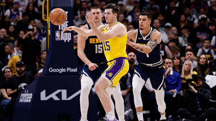 Apr 29, 2024; Denver, Colorado, USA; Los Angeles Lakers guard Austin Reaves (15) passes the ball as Denver Nuggets center Nikola Jokic (15) and forward Michael Porter Jr. (1) defend in the third quarter during game five of the first round for the 2024 NBA playoffs at Ball Arena. Mandatory Credit: Isaiah J. Downing-Imagn Images