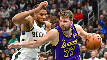 Mar 13, 2025; Milwaukee, Wisconsin, USA;  Los Angeles Lakers guard Luka Doncic (77) drives to the basket against Milwaukee Bucks forward Giannis Antetokounmpo (34) in the third quarter at Fiserv Forum. Mandatory Credit: Benny Sieu-Imagn Images