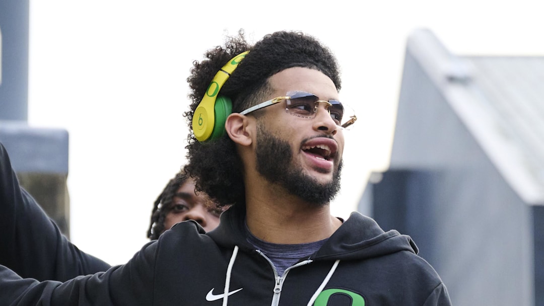 Nov 14, 2025; Eugene, Oregon, USA; Oregon Ducks quarterback Dante Moore (5) swipes his hand over the letter “O” during the “March to Victory” team walk before a game against the Minnesota Golden Gophers at Autzen Stadium. Mandatory Credit: Troy Wayrynen-Imagn Images