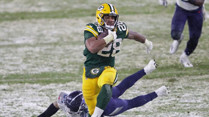 Green Bay Packers running back A.J. Dillon (28) breaks away from Tennessee Titans strong safety Kenny Vaccaro (24) for a touchdown run in the third quarter during their football game on December 27, 2020, at Lambeau Field in Green Bay, Wis.