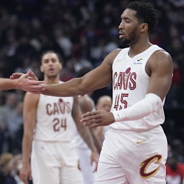 Feb 12, 2025; Toronto, Ontario, CAN; Cleveland Cavaliers guard Sam Merrill (5) and guard Donovan Mitchell (45) celebrate a basket against the Toronto Raptors at Scotiabank Arena. Mandatory Credit: John E. Sokolowski-Imagn Images