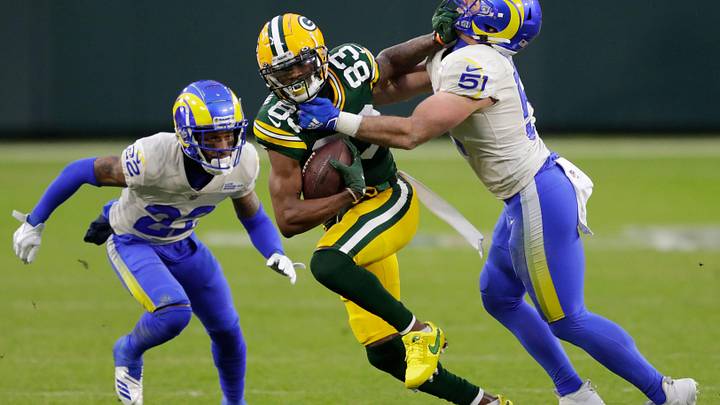 Green Bay Packers wide receiver Marquez Valdes-Scantling (83) runs for a first down on reception against Los Angeles Rams cornerback Troy Hill (22) and inside linebacker Troy Reeder (51) during their NFL divisional playoff game Saturday, January 16, 2021, at Lambeau Field in Green Bay, Wis.
