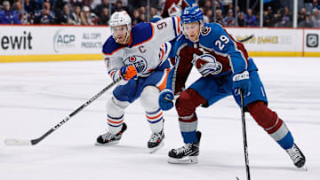 Feb 19, 2023; Denver, Colorado, USA; Colorado Avalanche center Nathan MacKinnon (29) controls the puck ahead of Edmonton Oilers center Connor McDavid (97) in overtime at Ball Arena. Mandatory Credit: Isaiah J. Downing-Imagn Images