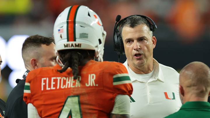 Oct 17, 2026; Miami Gardens, Florida, USA;  Miami Hurricanes head coach Mario Cristobal talks to running back Mark Fletcher Jr. (4) during the fourth quarter against the Florida State Seminoles at Hard Rock Stadium.  Mandatory Credit: Sam Navarro-Imagn Images