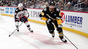 Jan 7, 2025; Pittsburgh, Pennsylvania, USA; Pittsburgh Penguins defenseman Marcus Pettersson (28) moves the puck ahead of Columbus Blue Jackets right wing Kevin Labanc (62) during the second period at PPG Paints Arena. Mandatory Credit: Charles LeClaire-Imagn Images