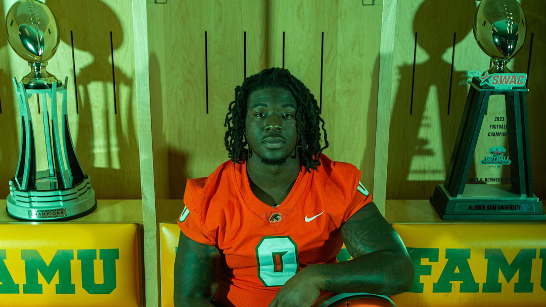 Florida A&M football player James Ash (0) poses in the locker room with the trophies the team won during the 2023 season.