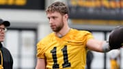 Iowa's senior football analyst Warren Ruggiero, left, talks to quarterback Mark Gronowski (11) during practice Thursday, April 3, 2025 in Iowa City, Iowa.