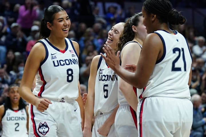 UConn Huskies center Jana El Alfy reacts with guard Paige Bueckers and forward Sarah Strong against the South Florida Bulls.