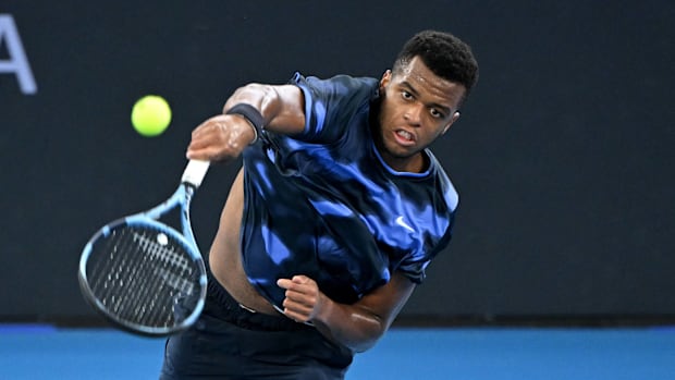 Giovanni Mpetshi Perricard serves against Frances Tiafoe in the Brisbane International.