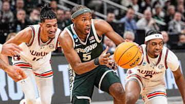 Michigan State guard Tre Holloman (5) dribbles against Auburn defenders during the South Regional final of NCAA men's tournament at State Farm Arena in Atlanta..