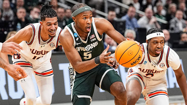 Michigan State guard Tre Holloman (5) dribbles against Auburn guard Denver Jones (2) and guard Chad Baker-Mazara (10) during the first half of the Elite Eight round of NCAA tournament at State Farm Arena in Atlanta, Ga. on Sunday, March 30, 2025.