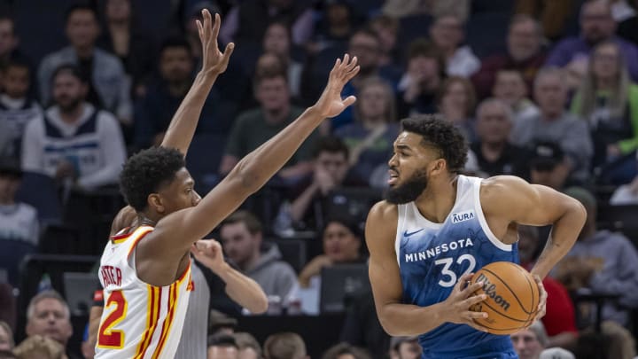 Apr 12, 2024; Minneapolis, Minnesota, USA; Minnesota Timberwolves center Karl-Anthony Towns (32) drives to the basket as Atlanta Hawks forward De'Andre Hunter (12) plays defense in the first half at Target Center. Mandatory Credit: Jesse Johnson-USA TODAY Sports