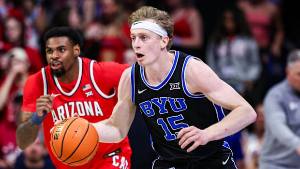BYU Cougars guard Richie Saunders (15) dribbles the ball while Arizona Wildcats guard KJ Lewis (5) pursues.