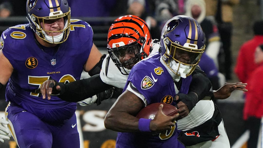 Bengals Joseph Ossai (58) helps take down Ravens Lamar Jackson (8) for the Bengals to take the ball during their game against the Ravens at M&T Bank Stadium on Thanksgiving Thursday November 27, 2025.